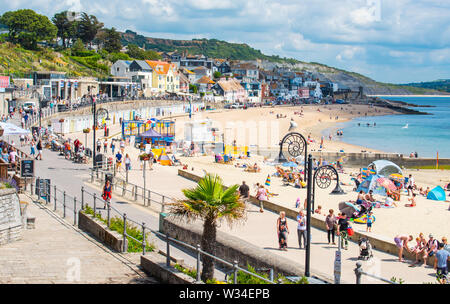 Lyme Regis, Dorset, UK. 12th July, 2019. UK Weather: Scorching hot sunshine and blue sky at Lyme Regis. Visitors flock to the sandy beach to enjoy the hot and sunny weather. Credit: Celia McMahon/Alamy Live News Stock Photo