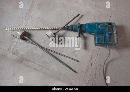 Large electric hammer drill with accessories for drilling concrete. The drill for drilling of large openings and big mills for concrete destruction. Stock Photo