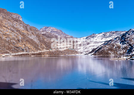 Tsomgo Lake (Tsongmo or Changu Lake) frozen during winter season. It is a glacial lake in East Gangtok Sikkim of India. Lake surface reflects differen Stock Photo