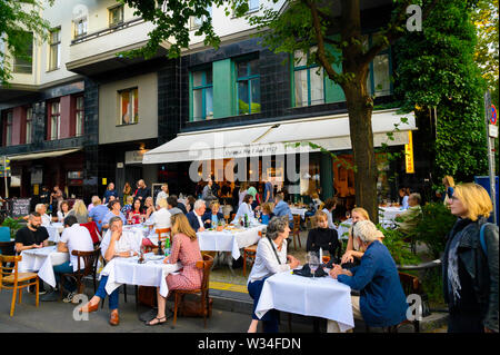 Berlin, Germany - June 28, 2019: Fully occupied tables and chairs at a street festival. Guests eating and drinking in a restaurant in the center of Be Stock Photo