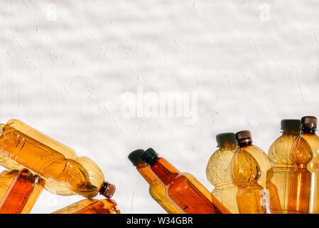 Plastic bottles on a white background with a texture. Natural lighting from the sun. Recycling and disposal of waste, environmental problems Stock Photo
