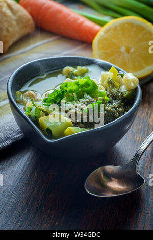 Vegetarian minestrone soup topped with pesto scallions and grated parmesan cheese Stock Photo