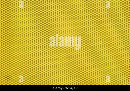 Yellow abstract background on based of metal, texture of the yellow surface with a lot of round holes. Stock Photo