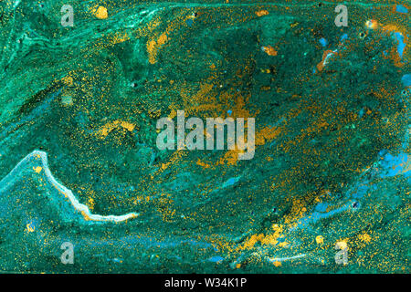 Liquid uneven green marbling pattern with golden glitter and glare of light Stock Photo