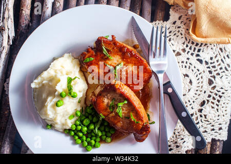 Honey jam glazed BBQ Pork chops with mashed potatoes and green peas Stock Photo