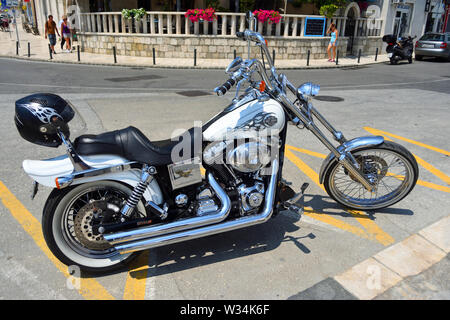 Harley Davidson Motorcycle parked in road with helmet on back. Stock Photo