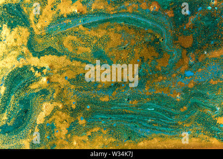 Liquid uneven green marbling pattern with golden glitter and glare of light Stock Photo