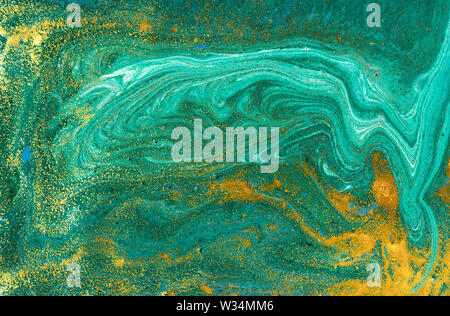 Liquid uneven green marbling pattern with golden glitter and glare of light Stock Photo