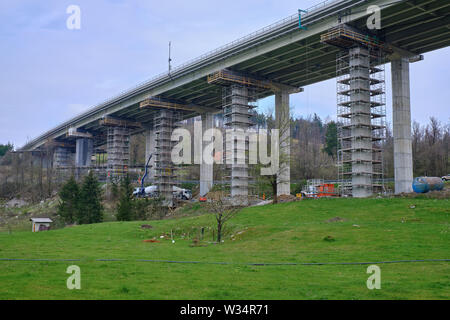 Slovenia: Crew of workers working on repair and maintenance of the substructure on an elevated highway.  Pylons are surrounded by scaffolding Stock Photo