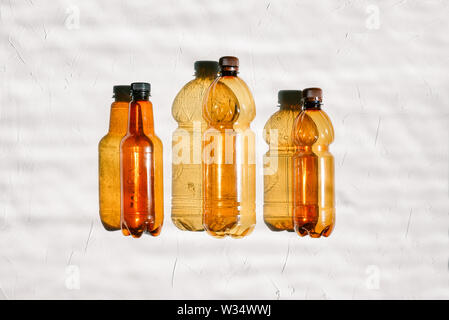 Background of plastic bottles. Three empty bottles in a row on a white background. Pollution and ecology concept. Recycling and disposal of garbage Stock Photo
