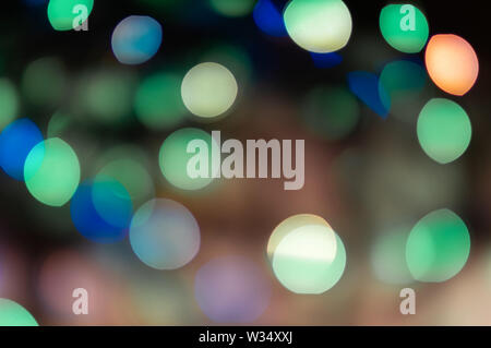 Beautiful multi-colored lights of Christmas garlands. Soft focus. Festive background. Stock Photo