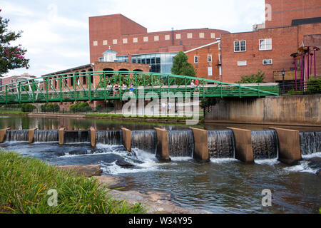 GREENVILLE, SC (USA) - July 5, 2019: A view of the Reedy River and waterfalls along the River Walk with the Eugenia Duke Bridge in the background. Stock Photo