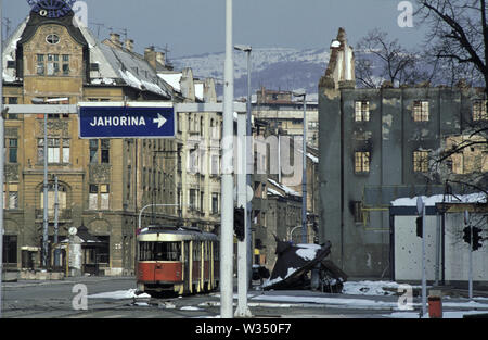 2nd April 1993 During the Siege of Sarajevo: a wrecked tram lies abandoned where 'Sniper Alley' ends and the old town of Sarajevo begins. Stock Photo