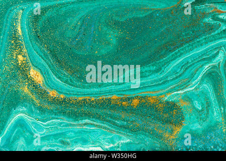 Liquid uneven green marbling pattern with golden glitter and glare of light Stock Photo