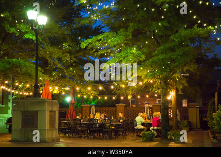 GREENVILLE, SC (USA) - July 5, 2019:  People eating at an outdoor cafe after dark in downtown Greenville. Stock Photo