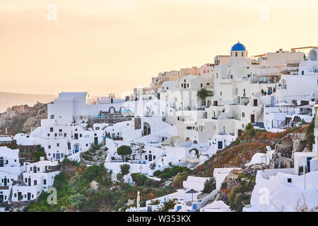 Tourists in restaurants and on Oia Castle wait for the sunset with Caldera View and the famous Windmill in Oia, Santorini , Greece at 04 June 2019. © Stock Photo