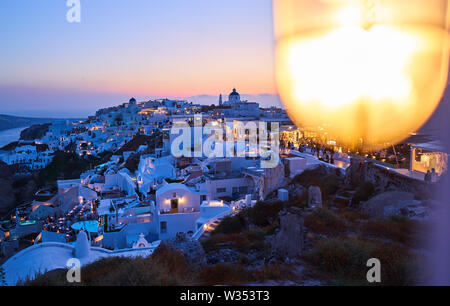 Tourists in luxury restaurants and on Oia Castle wait for the sunset with Caldera View and the famous Windmill in Oia, Santorini , Greece at 04 June 2