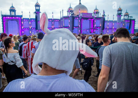 Neustadt Glewe, Germany. 12th July, 2019. Visitors dance at the Electro-Festival 'Airbeat One' in front of the grandstand. The festival is one of the largest electronic music festivals in Northern Germany and, according to the organizers, had 180,000 visitors over several days last year. Credit: Jens Büttner/dpa-Zentralbild/dpa/Alamy Live News Stock Photo