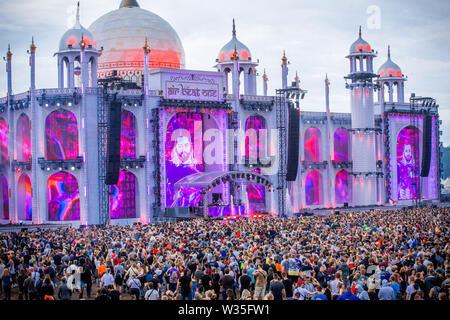 Neustadt Glewe, Germany. 12th July, 2019. Visitors dance at the Electro-Festival 'Airbeat One' in front of the grandstand. The festival is one of the largest electronic music festivals in Northern Germany and, according to the organizers, had 180,000 visitors over several days last year. Credit: Jens Büttner/dpa-Zentralbild/dpa/Alamy Live News Stock Photo