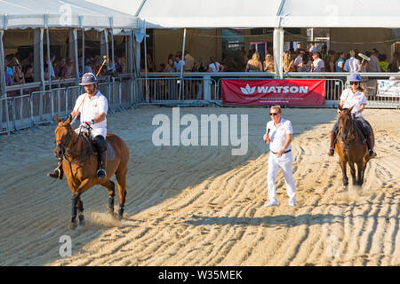 Sandbanks, Poole, Dorset, UK 12th July 2019. The Sandpolo British Beach Polo Championships gets underway at Sandbanks beach, Poole on a warm sunny day. The largest beach polo event in the world, the two day event takes place on Friday and Saturday, as visitors head to the beach to see the action. Actress and EastEnders star Rita Simons takes part in a penalty shoot out against Nick Knowles with Harry Redknapp commentating and overseeing. Credit: Carolyn Jenkins/Alamy Live News Stock Photo