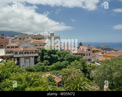 View over the red tiled roofs of the old town of La Orotava in the north of the Canary Island of Tenerife. In front of it the dark blue, calm Atlantic Stock Photo