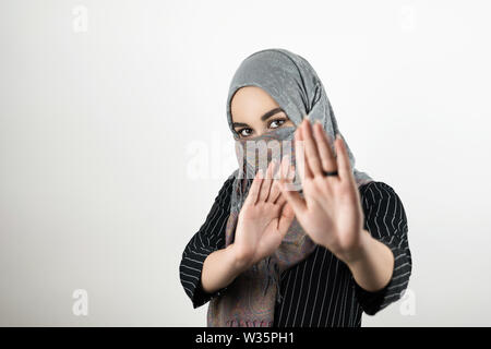young attractive Muslim student wearing turban hijab headscarf saying no to war isolated white background Stock Photo