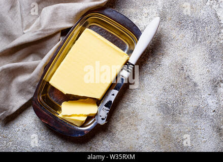 Fresh butter and knife in butter-dish Stock Photo