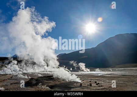 Atacama desert, Chile: Bright sun rise above El Tatio geyser field with many geysers, hot springs, and associated sinter deposits Stock Photo