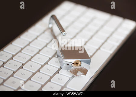 Stainless padlock on computer keyboard. PC network security, data security and antivirus protection concept. - Image Stock Photo