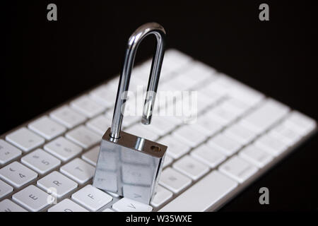 Stainless padlock on computer keyboard. PC network security, data security and antivirus protection concept. - Image Stock Photo