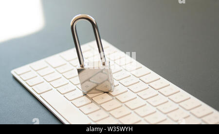 Stainless padlock on computer keyboard. PC network security, data security and antivirus protection concept. - Image Stock Photo