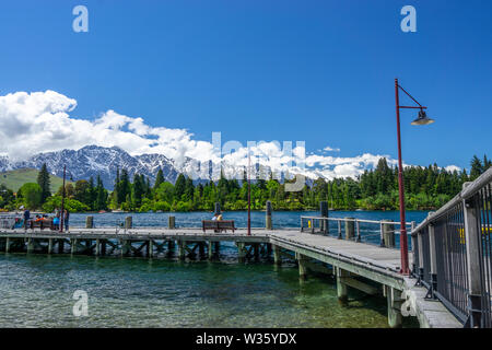 Queenstown wharf on shore of Lake Wakatipu with mountains in background, Queenstown, South Island New Zealand Stock Photo