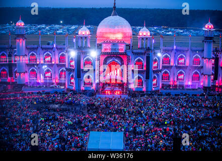 Neustadt Glewe, Germany. 12th July, 2019. Visitors dance in front of the main stage of the electro festival 'Airbeat One'. The festival is one of the largest electronic music festivals in Northern Germany and, according to the organizers, had 180,000 visitors over several days last year. Credit: Jens Büttner/dpa-Zentralbild/dpa/Alamy Live News Stock Photo