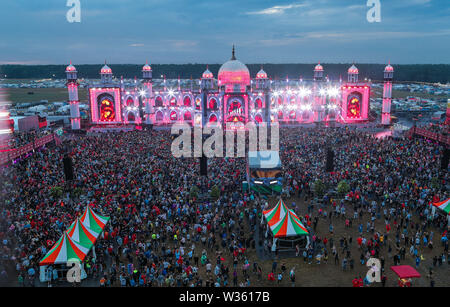 Neustadt Glewe, Germany. 12th July, 2019. Visitors dance in front of the main stage of the electro festival 'Airbeat One'. The festival is one of the largest electronic music festivals in Northern Germany and, according to the organizers, had 180,000 visitors over several days last year. Credit: Jens Büttner/dpa-Zentralbild/dpa/Alamy Live News Stock Photo