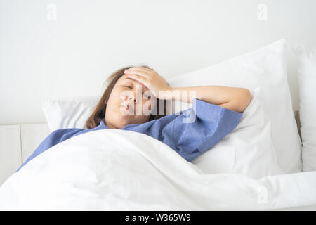 Asian Beautiful Woman Hypothermia has been measured by fever. Lie on the bed to give a body of rehabilitation. The concept of medical care to patients Stock Photo