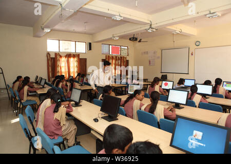 Schoolboy in computer lab with teacher helping Stock Photo - Alamy