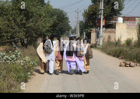 Rear view of schoolgirls walking to school Stock Photo