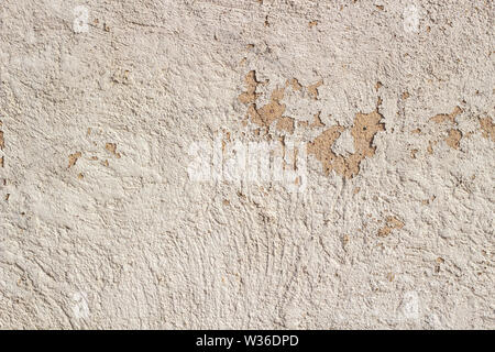 Old cracked weathered shabby beige painted plastered peeled wall background Stock Photo