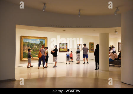 New York, USA. 12th July, 2019. Visitors view paintings at the Guggenheim Museum in New York, the United States, July 12, 2019. The Solomon R. Guggenheim Museum in New York City, often referred to as The Guggenheim, has been added to UNESCO's World Heritage List.    The museum is among eight buildings in the United States that were inscribed on the list under the title of The 20th-Century Architecture of Frank Lloyd Wright. The announcement was made during the 43rd Session of the World Heritage Committee held in Baku, Azerbaijan from June 30 to July 10. Credit: Xinhua/Alamy Live News Stock Photo