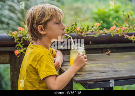 Boy drinking juice in a cafe. What to do with children. Child friendly place Stock Photo