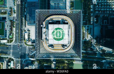 Aerial top view of helipad on the roof of a skyscraper iin downtown with cityscape view on sunny day Stock Photo