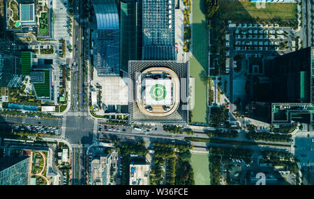 Aerial top view of helipad on the roof of a skyscraper iin downtown with cityscape view on sunny day Stock Photo