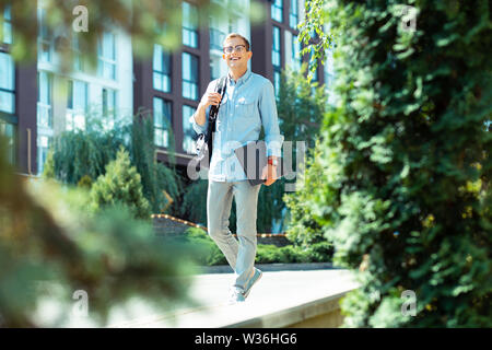 Software developer smiling while walking to the office in the morning Stock Photo