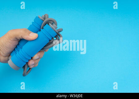 Skipping rope or jumping rope isolated on blue background. Selective focus and crop fragment Stock Photo