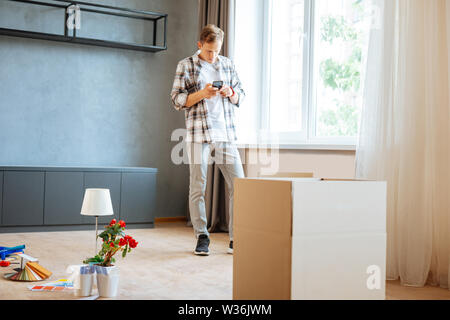 Husband standing in the room while moving to new flat Stock Photo