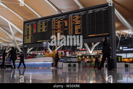 Wide shot of airport timetable arrivals and departures board with changing flight information Stock Photo