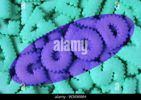 Heap of aqua blue alphabet shaped cookies of the word GOOD in purple colored Stock Photo
