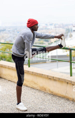 Black man doing stretching before running in urban background Stock Photo