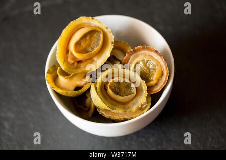 Commom limpets, Patella vulgata, that have been gathered while seashore foraging in Dorset. They will be used to make a dish popular in the Azores cal Stock Photo