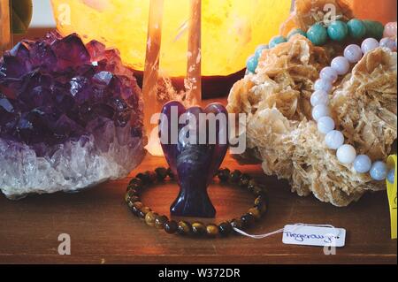 Amethyst Angel with other minerals on a table Stock Photo
